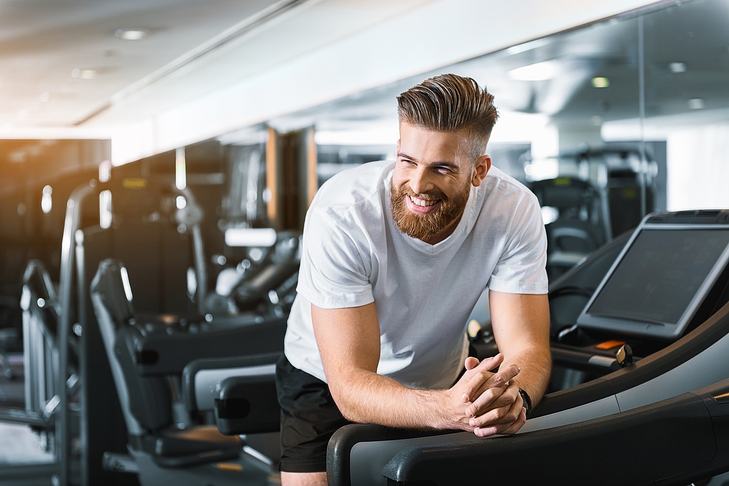 Man smiling at gym equipment.