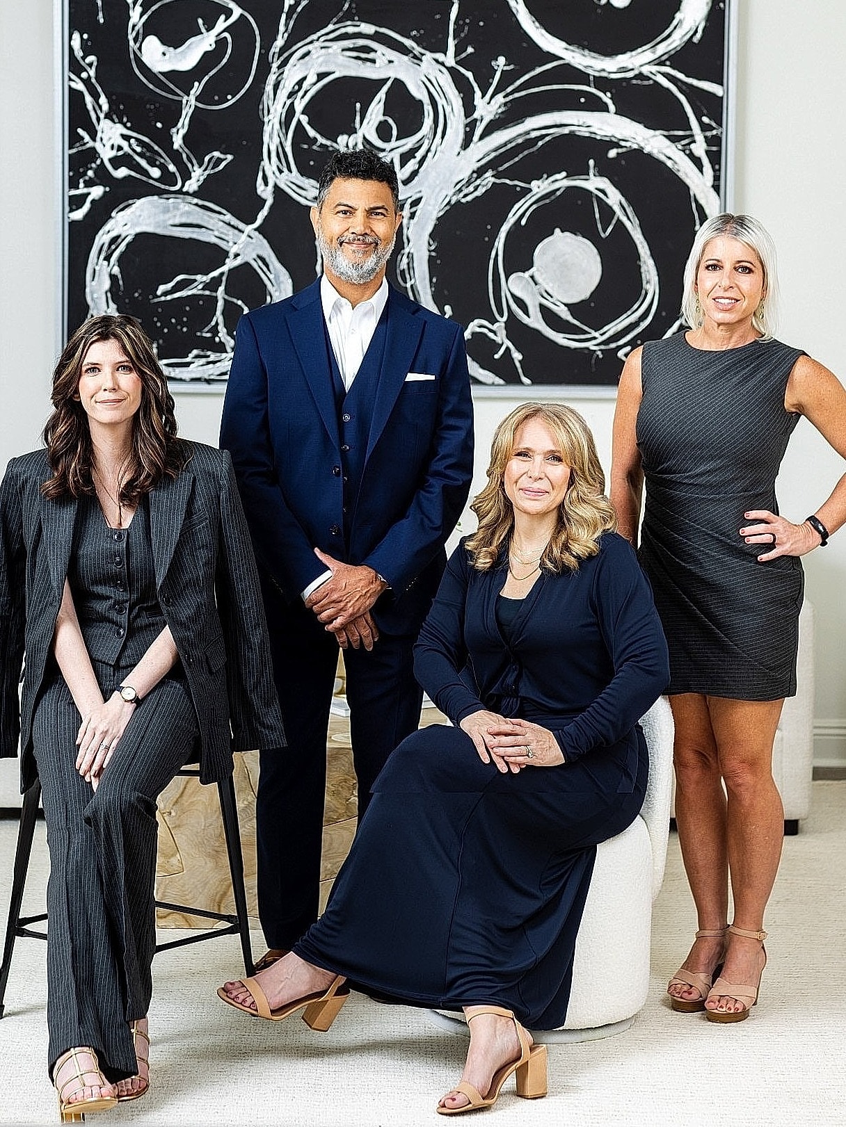 Group portrait of four professionals in stylish attire.